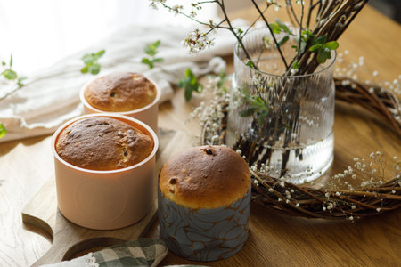 Easter traditional bread on rustic wooden table with flowers. Fresh baked homemade easter cake in forms. Orthodox traditional food paskaの写真素材