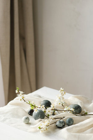 Stylish easter eggs and gentle, spring flowers and linen cloth composition on rustic white table. Space for text. Happy Easter! Natural painted marble eggs. Seasons greetingsの写真素材