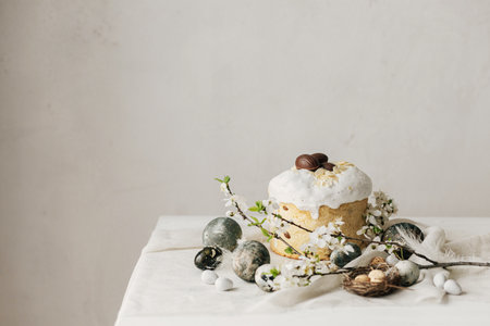 Happy Easter! Stylish easter eggs, homemade easter bread and spring flowers on linen napkin on...