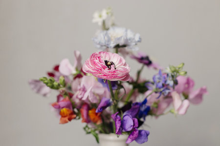 Stylish bouquet close up on rustic background. Beautiful colorful anemone, ranunculus, lathyrus scabiosa in vase. Summer flowers, floral moody still life. Space for textの写真素材