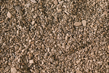 Pebbles background. Top view of river stones shingle , mineral material for pathways in modern urban garden or construction siteの写真素材