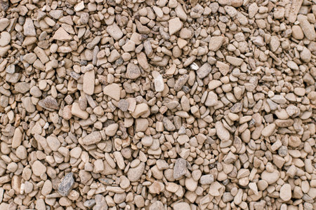 Pebbles background. Top view of river stones shingle , mineral material for pathways in modern urban garden or construction siteの写真素材