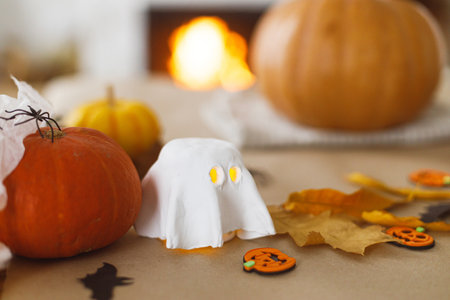 Ghosts and spiders, pumpkin on table in living room. Halloween preparation, Carve a pumpkin. Making halloween decorations, space for text.の写真素材