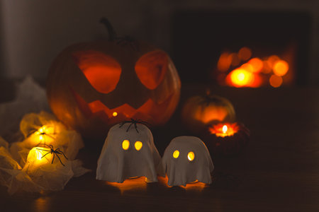 Glowing ghosts with spiders and glowing Jack o lantern in dark. Happy Halloween! Spooky atmospheric halloween decorations, space for textの写真素材