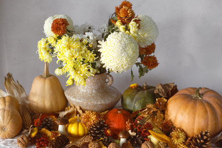 Happy Thanksgiving. Pumpkins and chrysanthemum in vase, fall leaves, berries and pine cones on table, space for text. Autumn harvest still life.  Fall bannerの写真素材