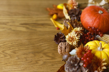 Thanksgiving background. Pumpkins, fall leaves and flowers, berries and pine cones on wooden background with space for text. Autumn banner. Fall harvestの写真素材