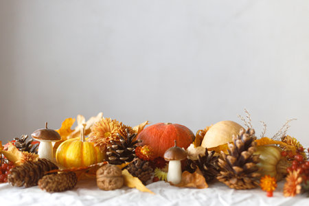 Happy Thanksgiving. Pumpkins, fall leaves and flowers, berries, mushroom and pine cones on linen cloth, space for text. Autumn banner. Fall harvest backgroundの写真素材