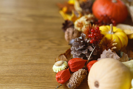 Thanksgiving background. Pumpkins, fall leaves and flowers, berries and pine cones on wooden background with space for text. Autumn banner. Fall harvestの写真素材