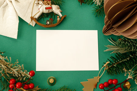 Christmas card flat lay. Modern greeting card mock up with fir branches, red berries and vintage ornaments on green background. Empty postcard template, space for text. Merry Christmasの写真素材