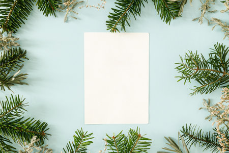 Christmas card mock up. Empty greeting card flat lay with fir branches on blue background. Merry Christmas. Season greetings minimal templateの写真素材