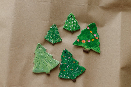 Christmas tree ornaments. Stylish handmade clay ornaments on craft wrapping paper flat lay. Christmas gift decoration. Winter handicrafts and holidays preparationの写真素材