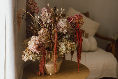 Dry hydrangea, poppy and amaranth in stylish vase close up. Fall decor in modern living room. Thanksgiving and Halloween. Autumn floral arrangementの写真素材