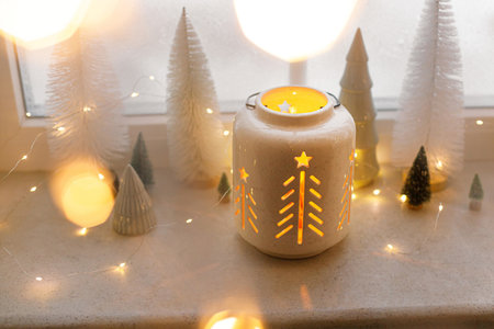 Glowing christmas lantern with golden lights bokeh and holiday decorations on window sill. Atmospheric magical still life. Merry Christmas and Happy Holidays! Winter wallpaper. Copy Spaceの写真素材