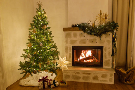 Stylish christmas tree with vintage baubles and golden lights in modern living room with festive decorated fireplace mantel. Festive xmas scandinavian room. Atmospheric magical eveの写真素材