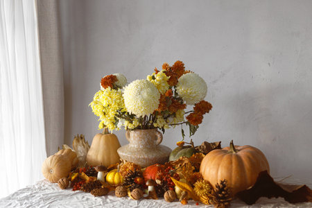 Thanksgiving background. Pumpkins and chrysanthemum in vase, fall leaves, berries and pine cones on table, space for text. Autumn harvest still life. Happy Thanksgiving. Fall bannerの写真素材
