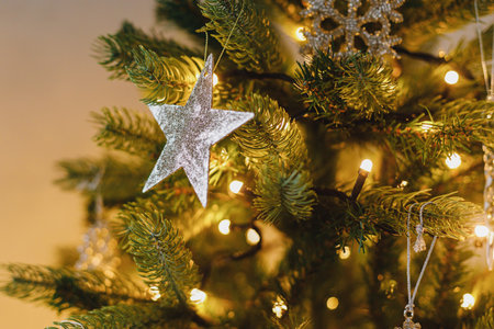 Beautiful decorated christmas tree with shiny star, vintage baubles and golden lights. Winter holidays preparation. Atmospheric magical eve. Stylish christmas ornament on tree close upの写真素材