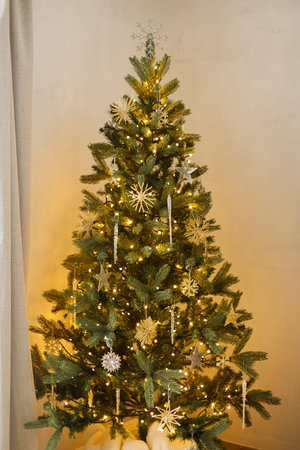 Merry Christmas! Beautiful decorated christmas tree with glass snowflake, vintage baubles and golden lights. Winter holidays preparation. Stylish christmas ornaments on treeの写真素材