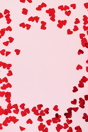 Valentines flat lay. Stylish red hearts confetti frame on pink background with copy space. Happy valentines day. Love bannerの写真素材