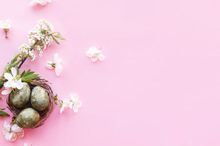 Easter flat lay. Stylish easter eggs in nest and flowers on pink background. Easter celebration,...