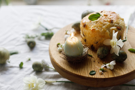Happy Easter! Stylish dyed eggs, easter cake on wooden stand, spring flowers and candle. Easter...