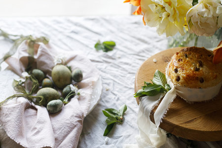 Happy Easter! Stylish eggs on napkin on plate, easter cake on stand, spring flowers. Easter...