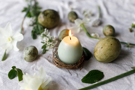 Easter. Stylish easter eggs, candle, flowers and cherry blossoms on linen cloth, space for text....