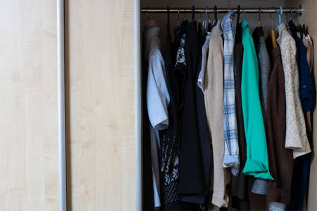 Wooden open wardrobe with women's clothing.の写真素材