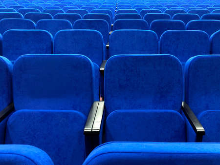 Rows of blue chairs in an empty concert hall.の写真素材
