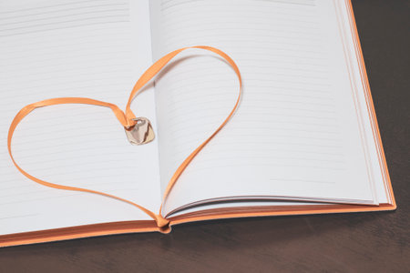 A beautiful heart in an open book in the form of a bookmark, a place for textの写真素材