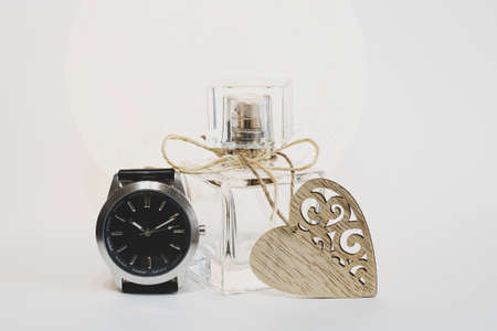 Women's perfume on a white background with a heart and a clock. Time to give gifts.の写真素材
