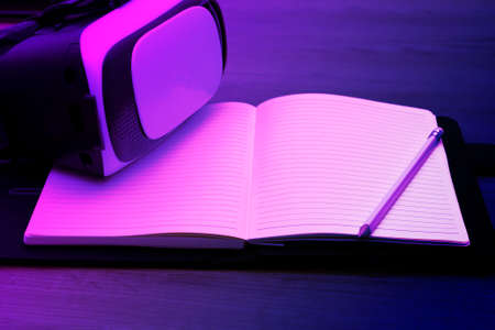 Virtual reality glasses lie on an open book, space for text on a multi-colored backgroundの写真素材