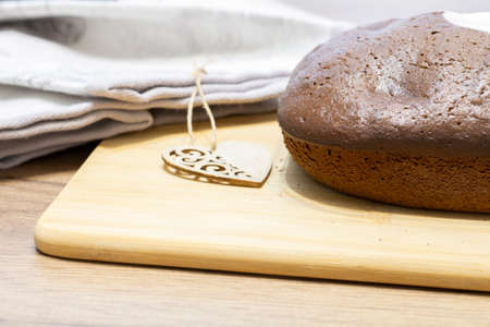 Homemade freshly baked chocolate cupcake on a wooden cutting board close-up, delicious dessert,...