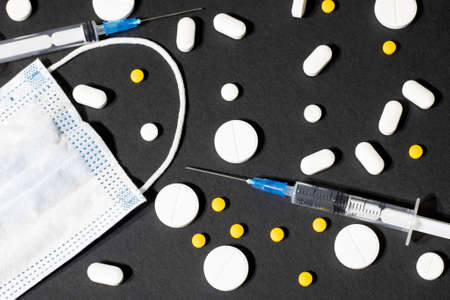 Syringes, medical mask and pills are scattered on the gray table, cosmetology and medicine.の写真素材