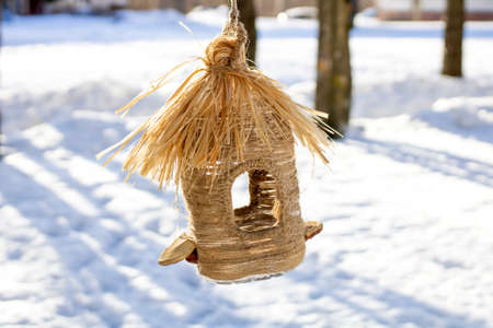 A beautiful birdhouse on a background of snow on a sunny dayの写真素材
