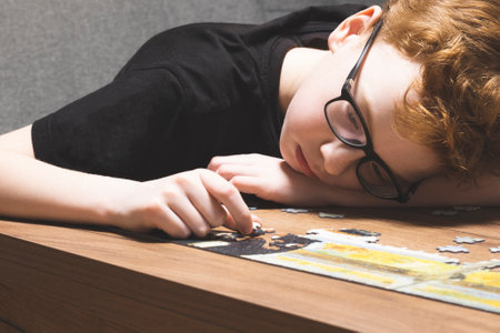 A teenage boy, frustrated and tired, collects puzzles.