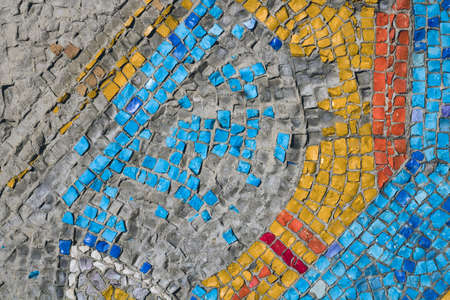 Background texture of colored stone mosaic laid out on the wall of a buildingの写真素材