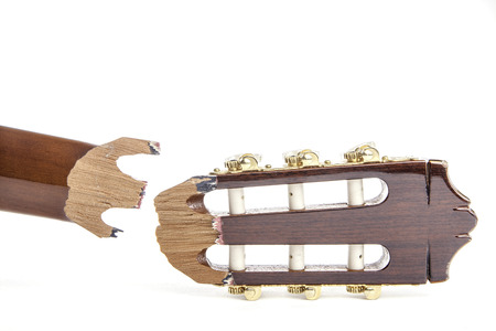 Headstock of a classical guitar that has snapped off and is awaiting repair. Isolated against a white background.の写真素材