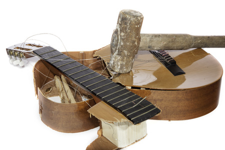 An acoustic guitar that has been smashed with a lump hammer by its frustrated guitarist owner. No more music practice.の写真素材