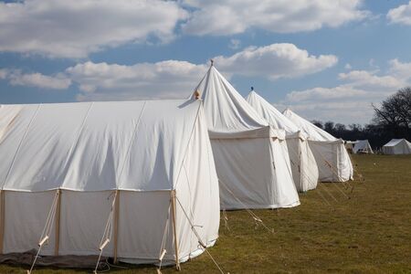 Napoleonic war white military camping tents pitched on the open fields of English countryside. A battlefield reenactment site.の写真素材