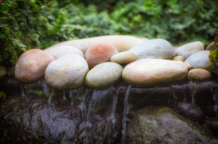 Zen waterfall. Soft image of stones over moving water.の写真素材