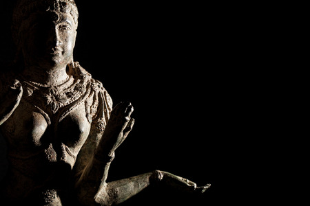 Religious artifact. Bronze statue of Hindu Goddess Lakshmi. Hinduism in close up. Museum quality exhibit against black background with copy space.の写真素材