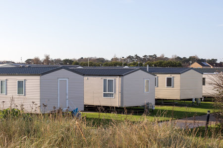 Modern beach holiday homes. A row of seaside vacation chalet lodges on the East coast of the UK.のeditorial素材
