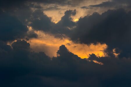 Break in the clouds. Sun emerging behind dark storm clouds. Weather or spiritual background image....