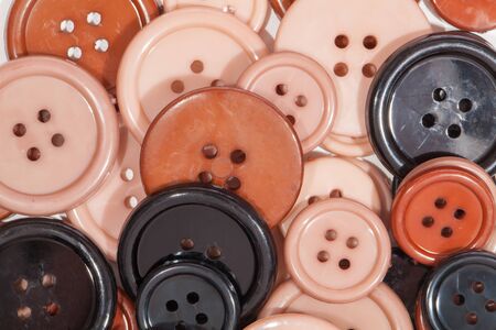 Plastic Buttons close-up. Childrens creative art and craft play background image. Simple brown cream pink and black painted discs for kids creativity.の写真素材