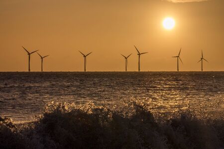 Renewable energy. Solar, wind and wave power represented in one image. Alternative energy from the sun, offshore wind turbines and breaking waves. Tackling global warming and climate change. UK coastの写真素材