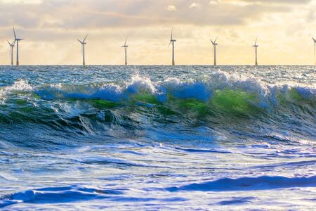 Green energy. Wind power and wave energy. Renewable sustainable resources from offshore wind farm turbines on the sea horizon. Environmental conservation for climate change and global warming.の写真素材