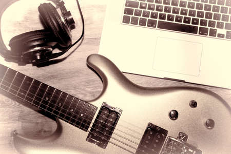 Music production. Writing music with an electric guitar, laptop computer and headphones. Flat lay image of modern music composition on a home studio desk. Guitarist musician desktop recording set up.の写真素材
