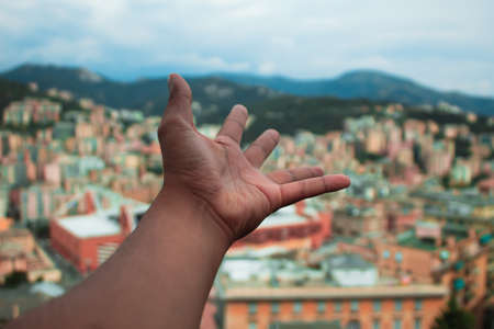 Cropped Hand Of Man Over Landscape In Cityの写真素材
