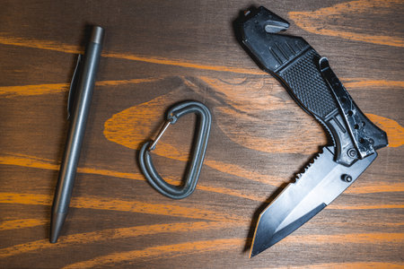 Flatlay background of some EDC gear, Knife, Carabiner and a pen.