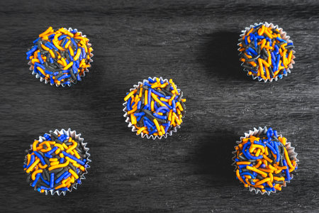 Typical Brazilian sweets, Brigadeiros. in Halloween colors, on a dark gray background. candies for...